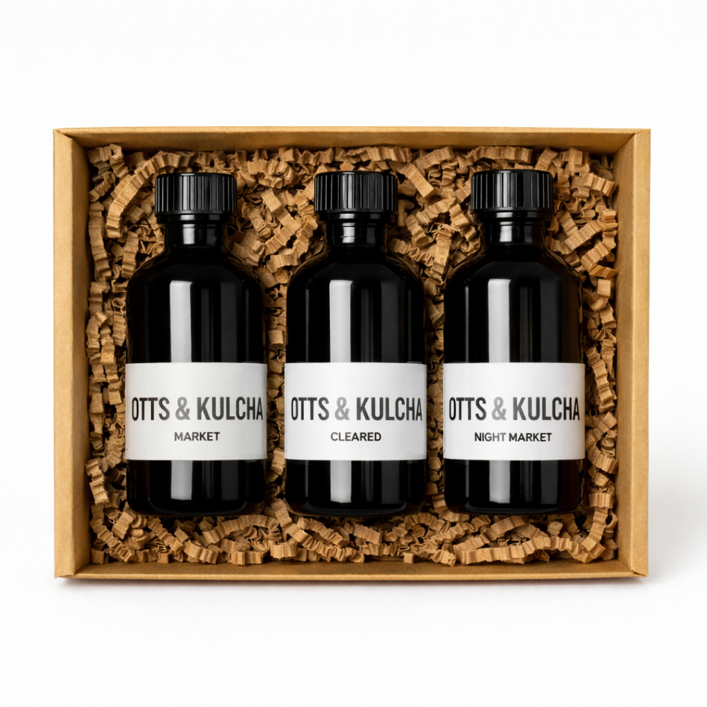 Three black bottles with labels in a Kraft box