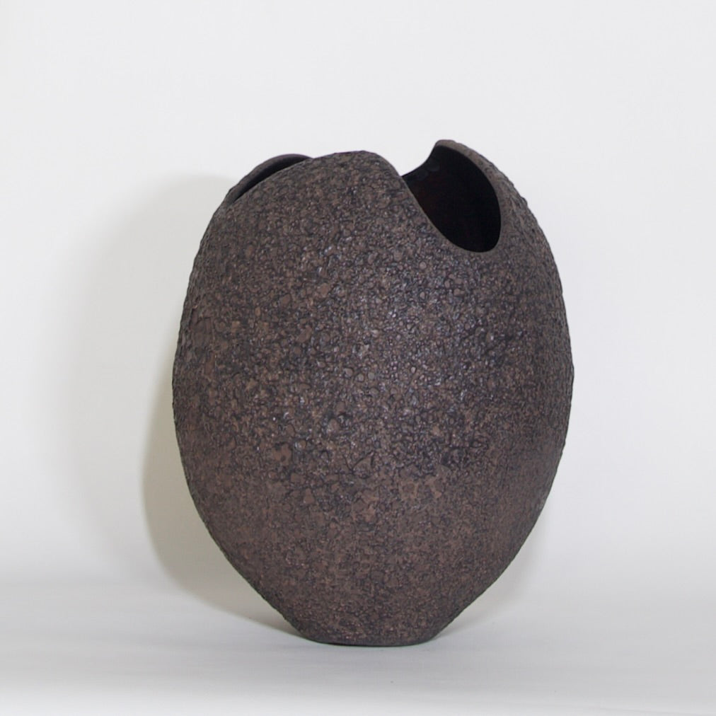 A dark brown textured ceramic vase with a unique asymmetrical split opening, shown against a plain white background.