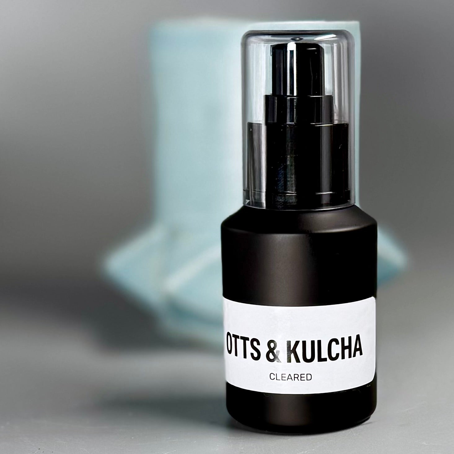 Skincare bottle with 'Ott's & Kulcha' label on a gray background