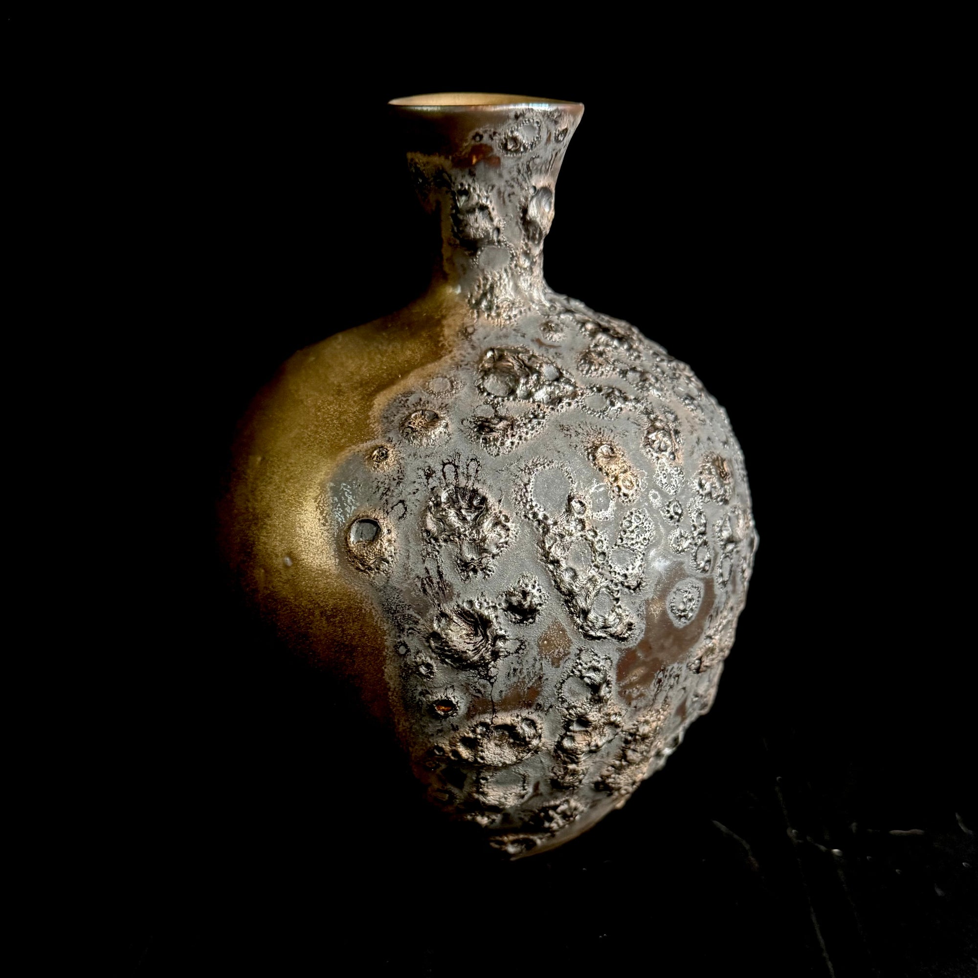 Textured ceramic vase on a black background