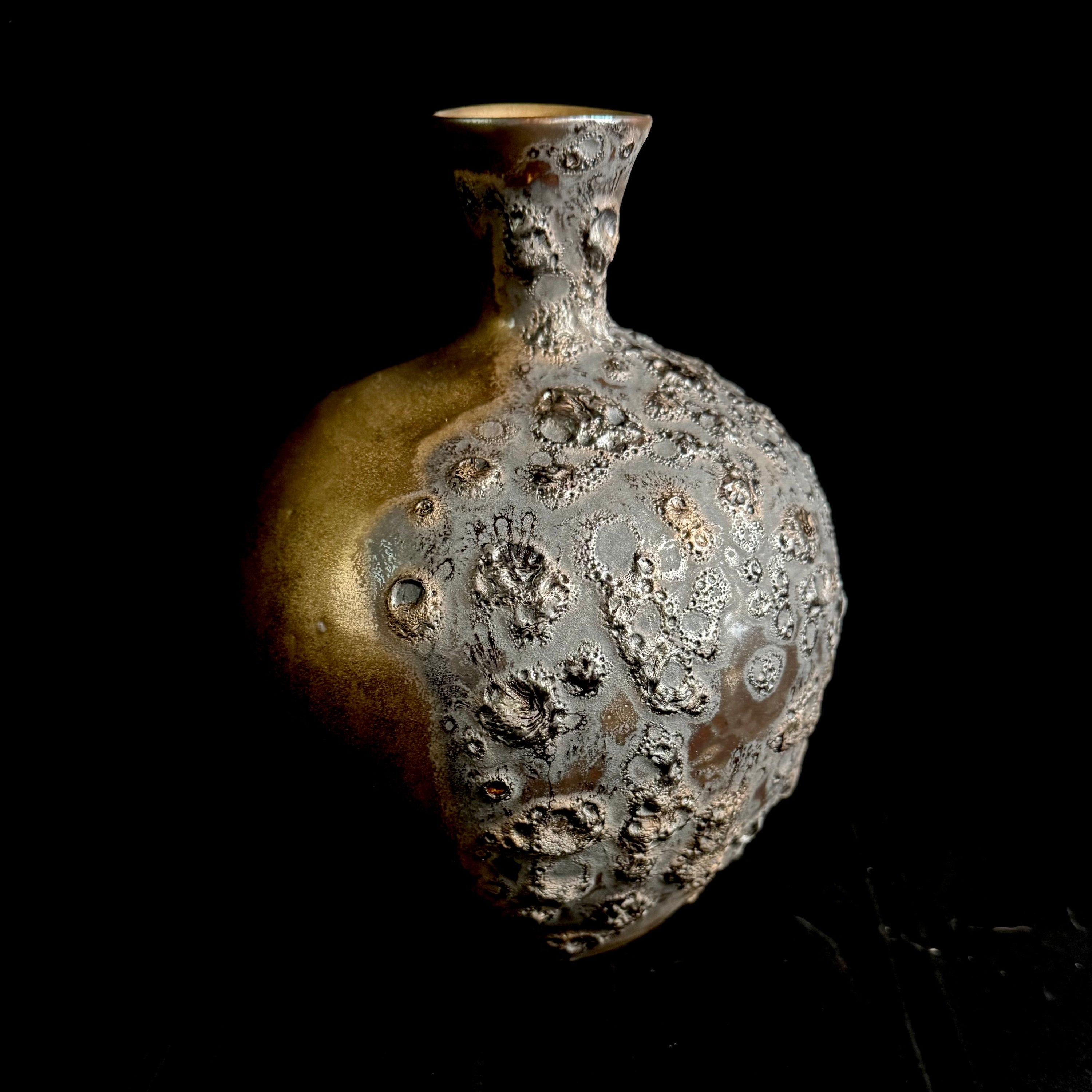 Textured ceramic vase on a black background